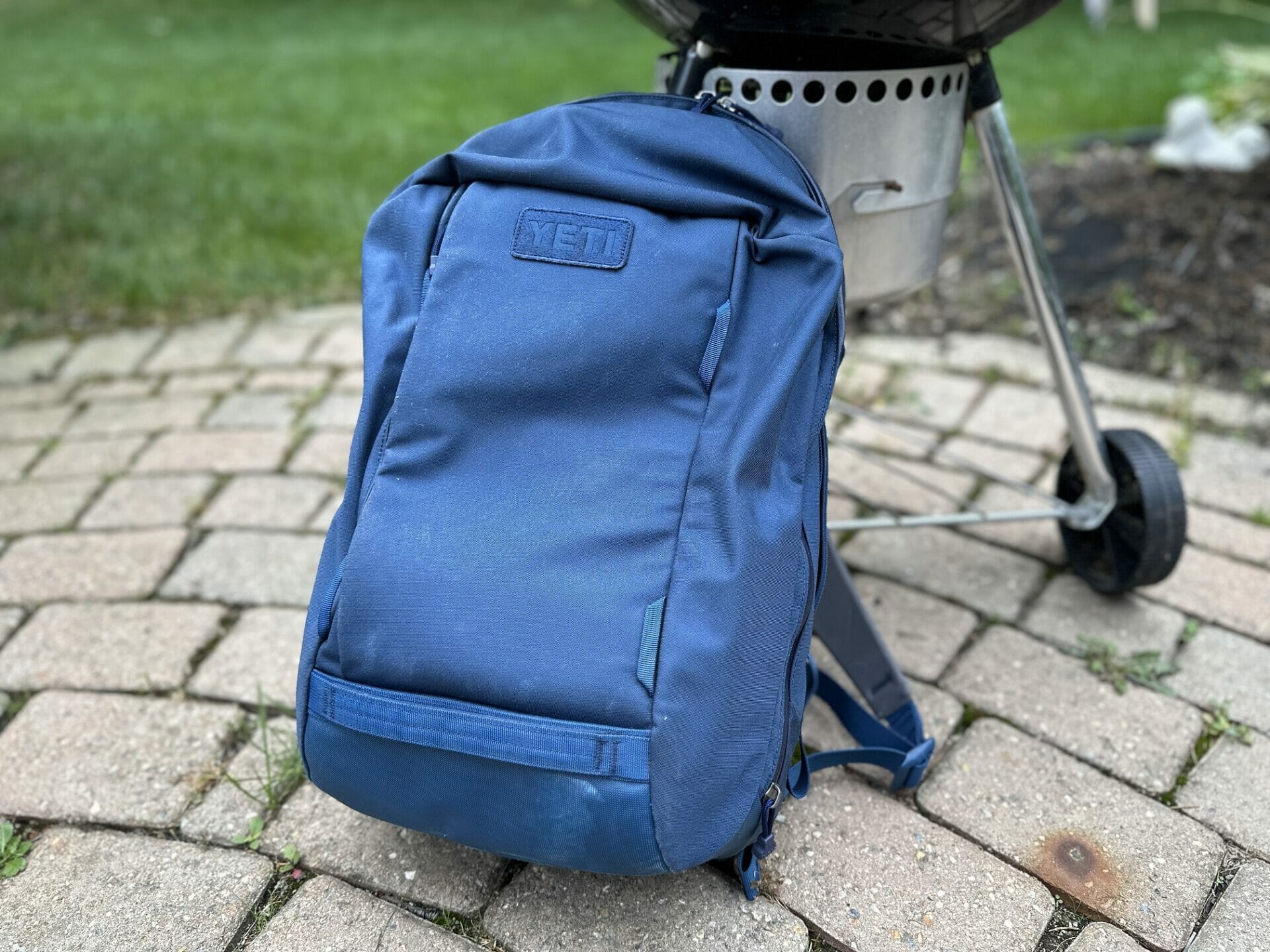 https://www.cookoutnews.com/wp-content/uploads/2023/08/Yeti-Crossroads-Backpack-in-Front-of-a-Weber-Kettle-Grill.jpg