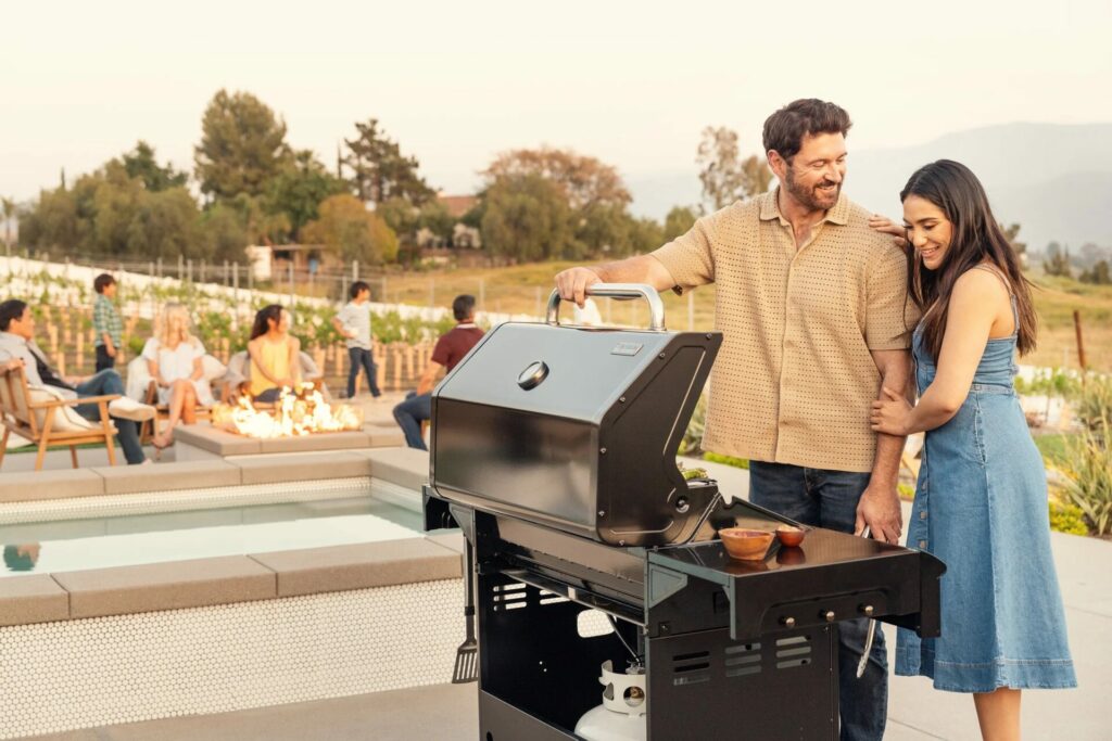 Man Showing Off His Nexgrill Deluxe 7-Burner Gas Grll