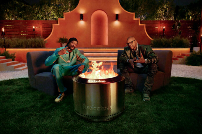 Snoop Dogg and Warren G sitting in front of a Solo Stove fire pit