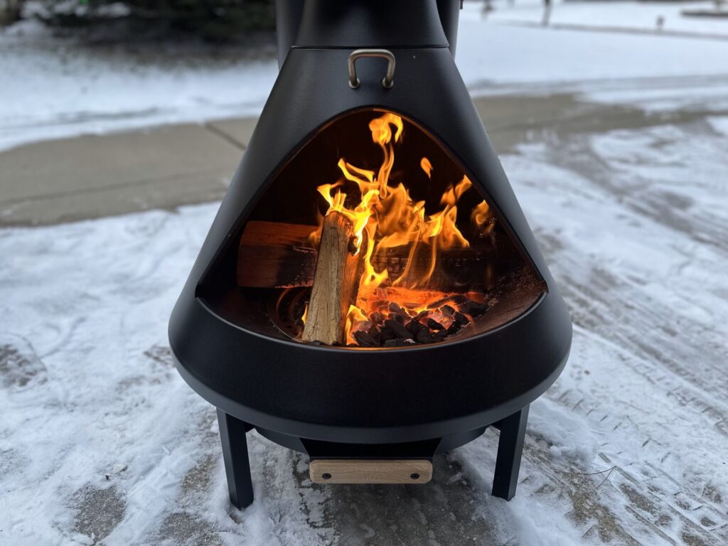 Burning Logs in the TIKI Brand Chiminea Outdoor Fireplace